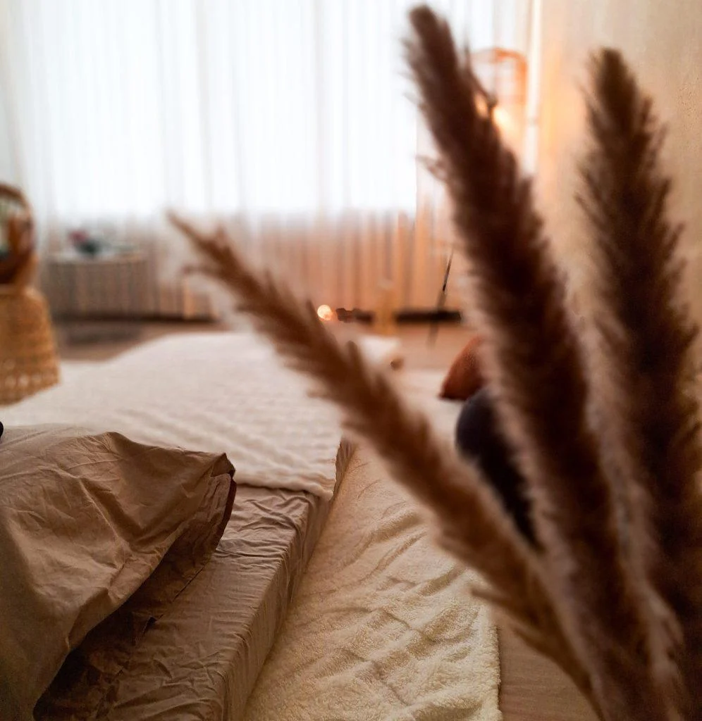 Rustige behandelruimte met matras en zachte verlichting – warme aardetinten voor ontspanning en ademwerk bij OPcoaching & Health in Breda.